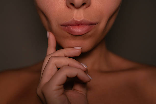 Close-up of young woman touching her chin with hand, 